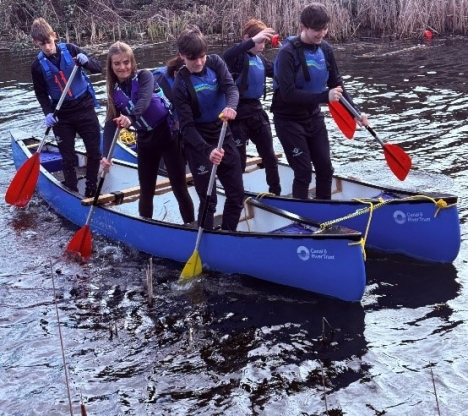 Multiple Waterside students paddling on canoe